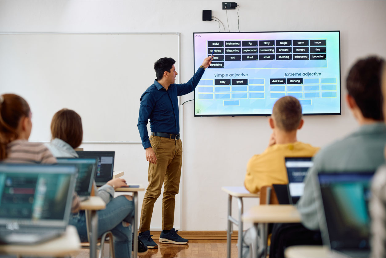 Professeur utilisant un écran numérique interactif pendant son cours